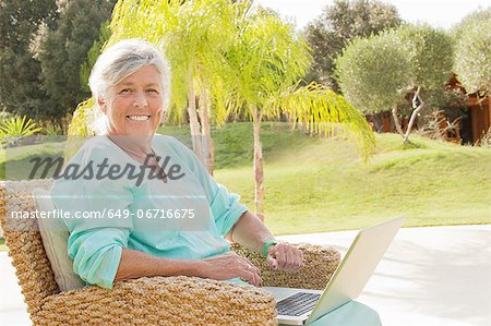 Older woman using laptop outdoors