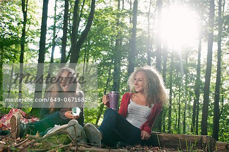 Teenage girls having picnic in forest