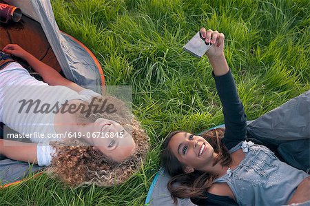 Teenage girls taking picture at campsite