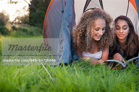 Teenage girls reading in tent