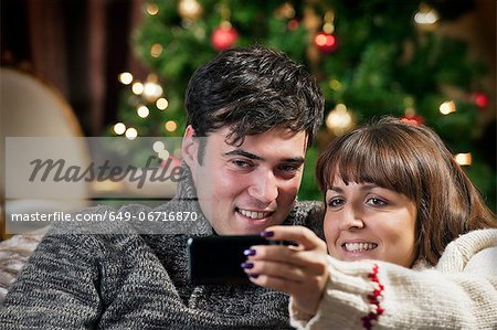 Couple taking cell phone picture on sofa
