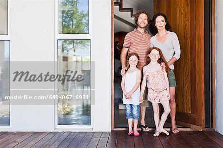Family smiling at front door