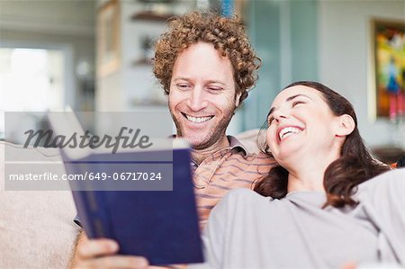 Couple reading together on sofa
