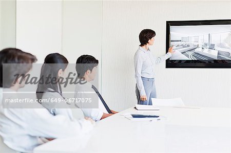 Businesswoman showing image to colleagues