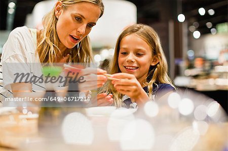 Mother and daughter using chopsticks