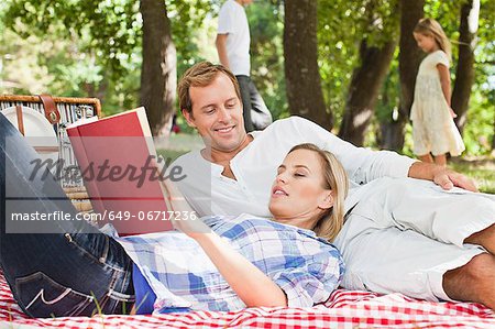 Couple relaxing on blanket in park