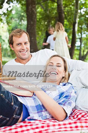 Couple relaxing on blanket in park