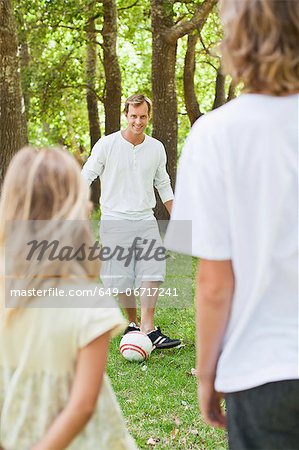 Father and children playing in park