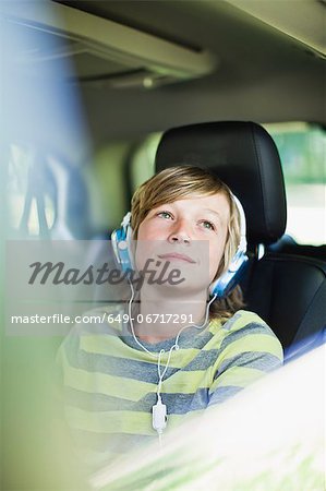 Boy listening to headphones in car