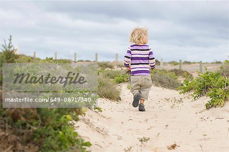 Toddler girl walking on beach