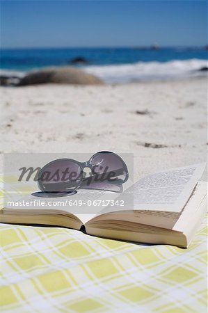 Sunglasses on book on beach