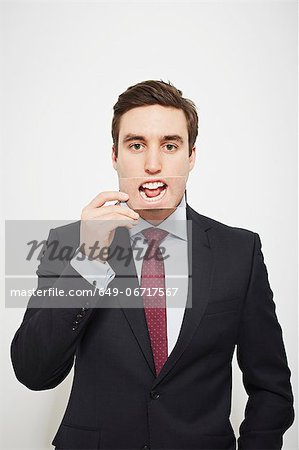 Businessman holding picture over his mouth