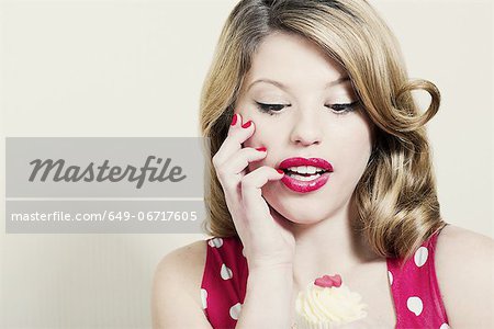Woman admiring cupcake indoors