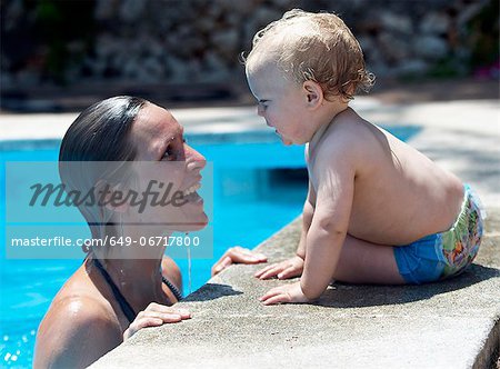 Mother and baby by swimming pool