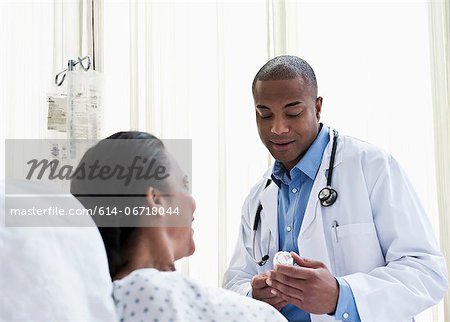 Doctor talking to patient in hospital, looking at medicine