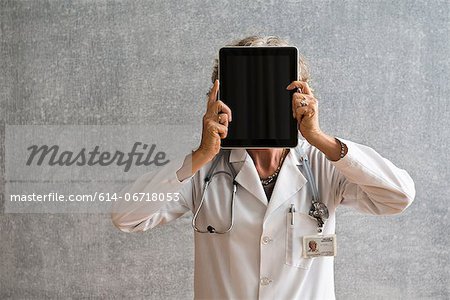 Female doctor holding digital tablet in front of face