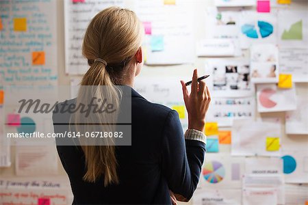 Woman holding pen, rear view Woman holding pen, rear view