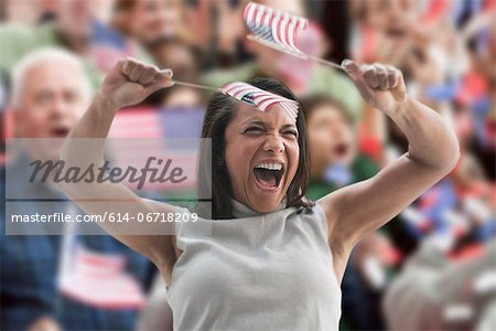 Excited woman waving american flags at rally