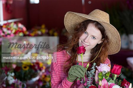 Florist smelling flowers in shop