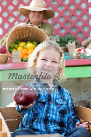 Boy holding apple at farmer's market