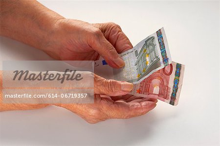 Older woman holding Euro notes