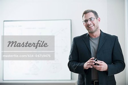 Businessman holding cell phone in office