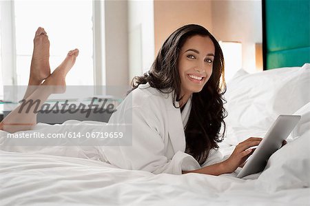 Woman in bathrobe using tablet computer