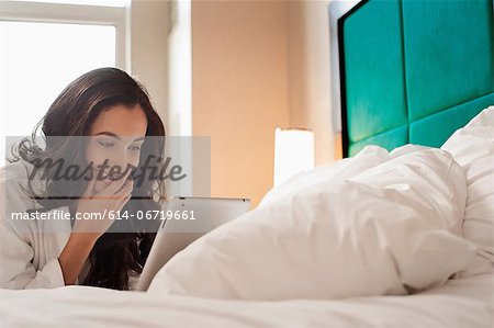 Woman in bathrobe using tablet computer