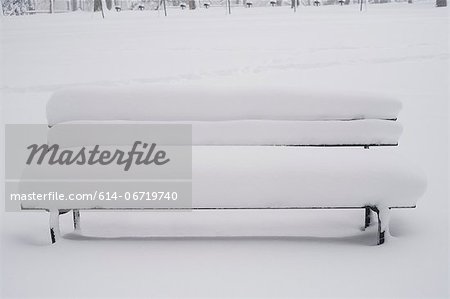 Snow covered bench in park Snow covered bench in park