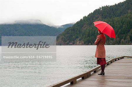 Woman with umbrella on wooden pier