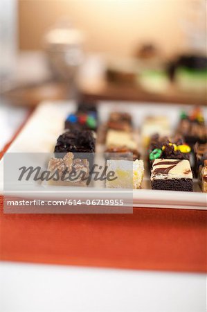 Plate of decorated desserts on table