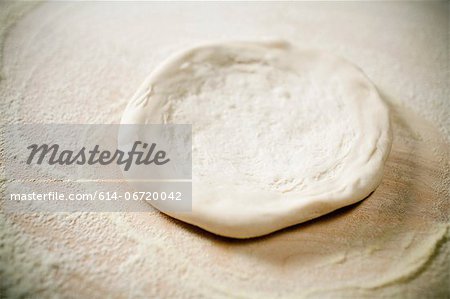 Close up of pizza dough being flattened