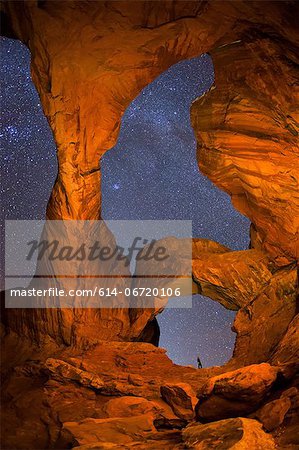 Hiker and night sky from Double Arch