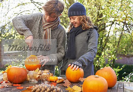 Children carving pumpkins together outdoors