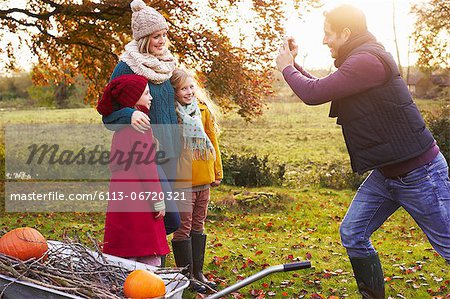 Father taking picture of family outdoors