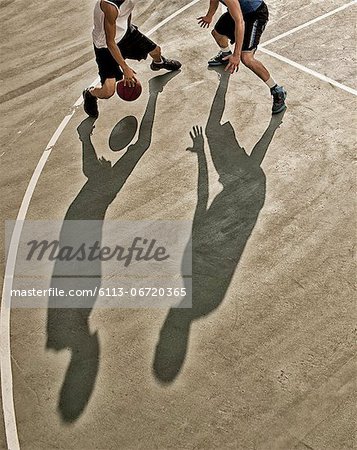 Men playing basketball on court