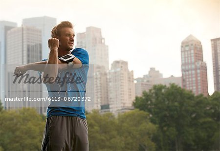 Runner stretching in urban park