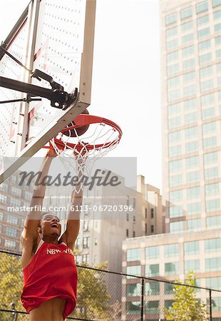 Man dunking basketball on court