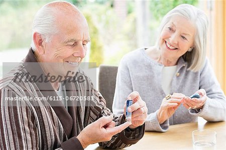 Older couple testing blood sugar together