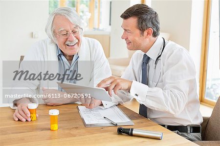 Doctor talking to older patient at house call