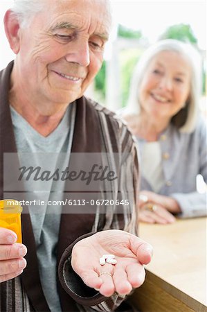 Older man with handful of pills