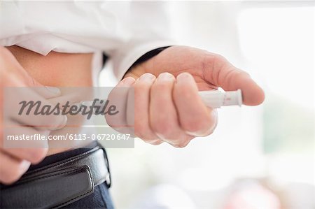 Man giving himself injection in stomach