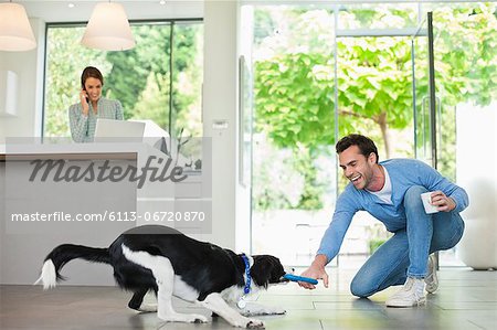 Man playing with dog in kitchen