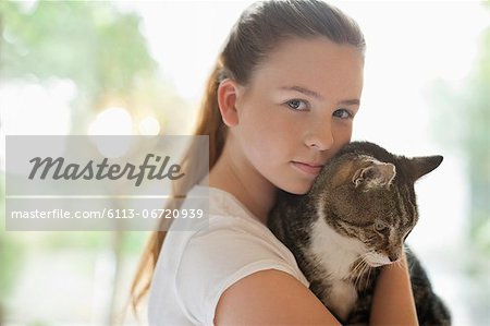 Girl holding cat indoors