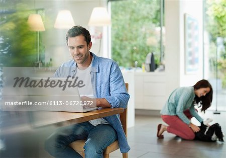 Man using laptop in kitchen