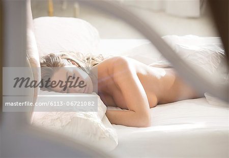 Nude woman sleeping in bed