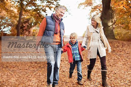 Older couple walking with grandson in park