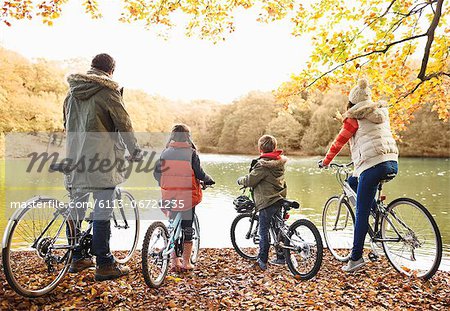 Family sitting on bicycles together in park