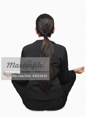 Rear view of a businesswoman meditating
