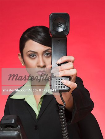 Businesswoman showing a telephone receiver